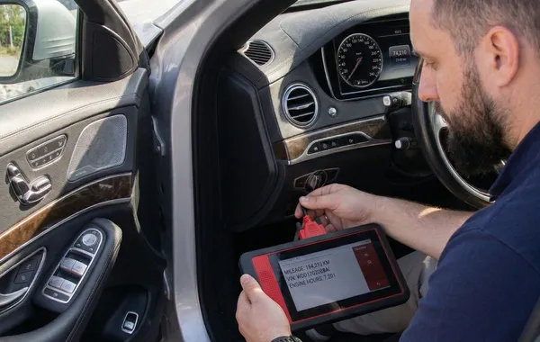 CarSherpa professional diagnostic scanner checking the real electronic mileage of an imported used car in Hungary to prevent odometer rollback scams.