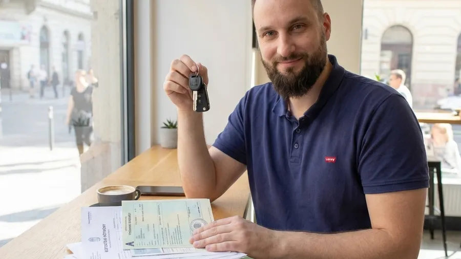 A relieved expat driver holding Hungarian car keys and insurance documents after successfully navigating the KGFB Bonus-Malus system.