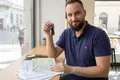 A relieved expat driver holding Hungarian car keys and insurance documents after successfully navigating the KGFB Bonus-Malus system.
